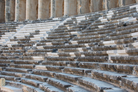 Part of the amphitheater with a stone staircase and a wall in the background. The wall has arches