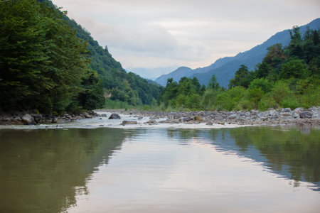 The calm water of the lake against the backdrop of the forested mountains of Georgia.の写真素材