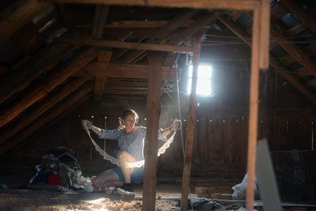 A woman sorts through things in an old attic. Antique finds.