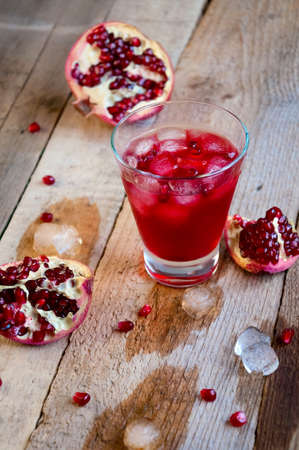 Pomegranate Cocktail with Ice and Fruit on Wooden Table. Refreshing Summer Drink Soft or Alcoholicの写真素材
