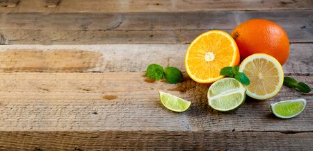 Ripe Citrus Fruit on the Old Wooden Table. Orange, Lime, Lemon Mint. Healthy Food. Summer Background.の写真素材
