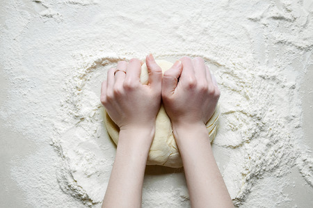 Woman Hands Kneads the Dough with Flour on the White Kitchen Tab