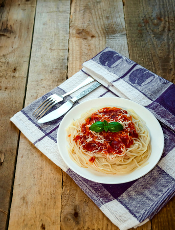 Spaghetti Pasta with Tomato Sauce, Cheese and Basil on Wooden Table. Traditional Italian Foodの写真素材