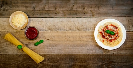 Spaghetti Pasta with Tomato Sauce, Cheese and Basil on Wooden Table. Traditional Italian Food.の写真素材