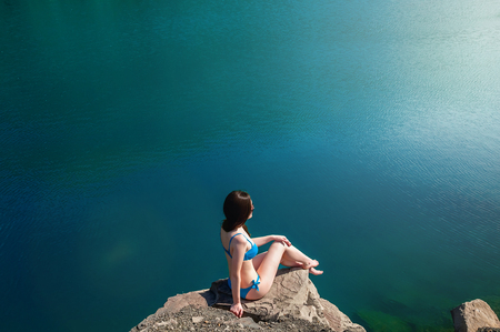 Beautiful Young Woman in Swimsuit Standing on the Lake In the Morning. Concept Tourism. Summer Backgroundの写真素材