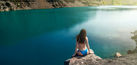 Beautiful Young Woman in Swimsuit Standing on the Lake In the Morning. Concept Tourism. Summer Backgroundの写真素材