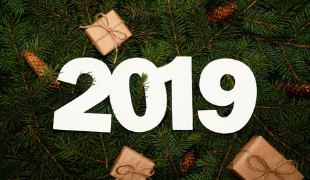 Number Two Thousand and Nineteen on Green Fir Branches with Small Gift Boxs. Creative Nature Concept. Minimal Holiday Composition. Flat Layの写真素材