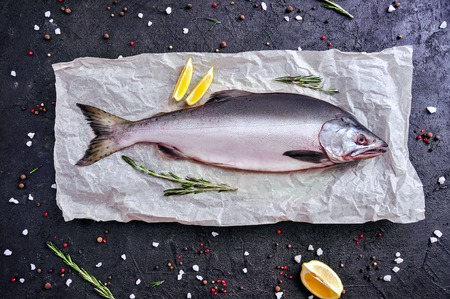 Raw Salmon Fish with Spices on Black Stone Background. Top View Flat Lay