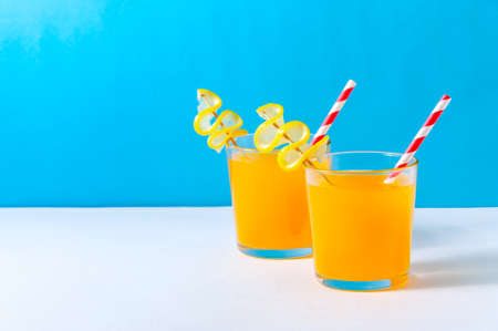 Cocktails with Orange Juice on Blue Background. Refreshing Summer Drink. Copy Space For Your Text