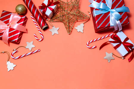 Christmas Composition with Gift Boxes, Branches Fir Tree, Papers Rools and Decorations on Red Background.の写真素材