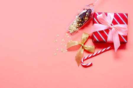 Christmas Composition with Gift Boxes, Santa Hat, Champagne Glass and Decorations on Pink Backgroundの写真素材