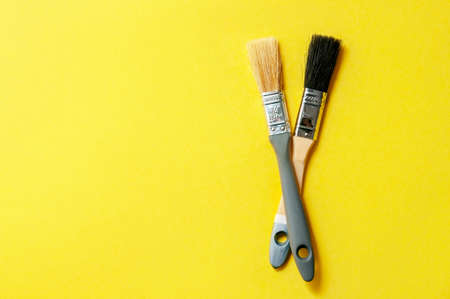 Color of the Year 2021. Gray Brushes on Yellow Background. Concept Repair