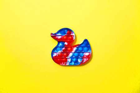 Trendy pop it toys in form of duck on yellow background. Top View Flat Layの写真素材
