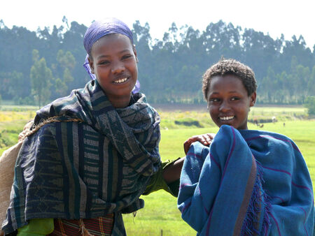 FINOTE SILAM, ETHIOPIA - NOVEMBER 24, 2008: Two strangers smiling Ethiopian girl closeup in Finote Silam, Ethiopia - November 24, 2008.  Nature landscape in the background.のeditorial素材