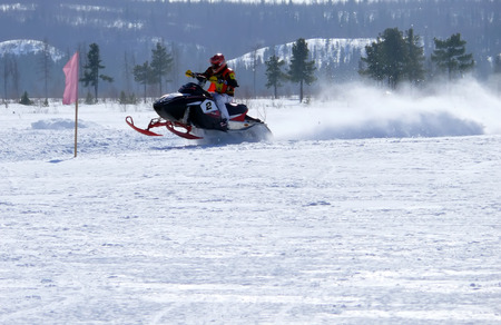 Nadim, Russia - April 12, 2008  Unknown athletes snowmobile race on speed  Snow cross-country race  Jump のeditorial素材