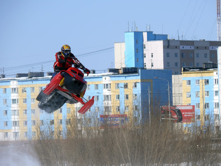 Nadim, Russia - April 12, 2008: Unknown athletes snowmobile race on speed. Snow cross-country race. Jump.のeditorial素材