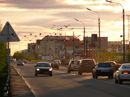 Nadym, Russia - June 26, 2008: the City skyline in Nadym, Russia - June 26, 2008. City Central road with riding on her car. Sunset over the city.のeditorial素材