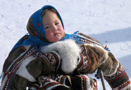 Nadym, Russia - March 18, 2006: the national holiday, the day of the reindeer herder in Nadym, Russia - March 18, 2006. Unknown girl in the Nenets woman on a sledge.のeditorial素材
