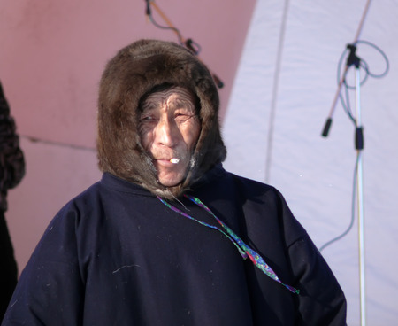 Nadym, Russia - March 15, 2008: the national holiday - the Day of the reindeer herder in Nadym, Russia - March 15, 2008. Unknown man Nenets on the stage and smokes.のeditorial素材