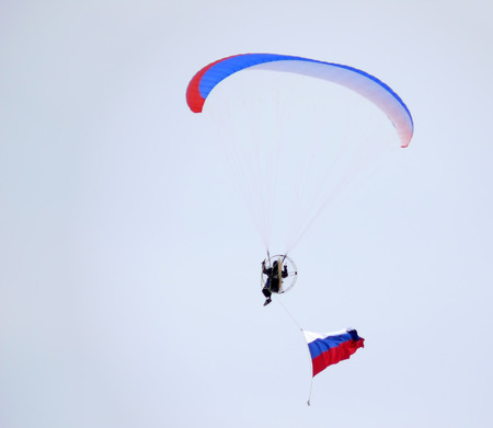 Nadym, Russia - March 16, 2008: Unknown man flying through the sky on a paraglider in Nadym, Russia - March 16, 2008.のeditorial素材