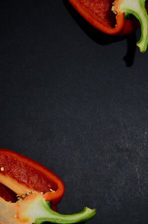 frame of halves of kars Bulgarian pepper on a black background vertical orientation