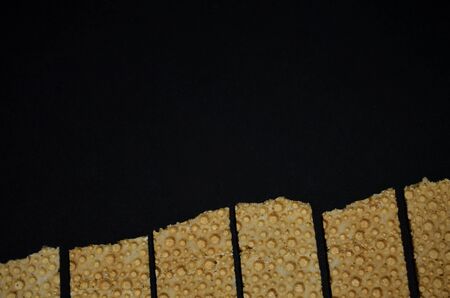 cereal waffle breads on the bottom edge on a black background with a copy space horizontal...