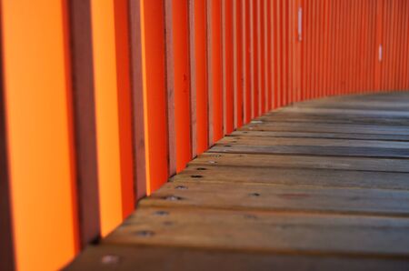 wooden walkway with orange railings close-upの写真素材