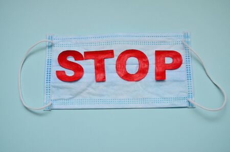 STOP in red letters on a medical mask light background horizontal orientation