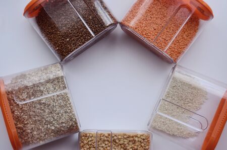 Cans of buckwheat oatmeal peas rice lentils lined circle on a white background over looking top with copy spaceの写真素材