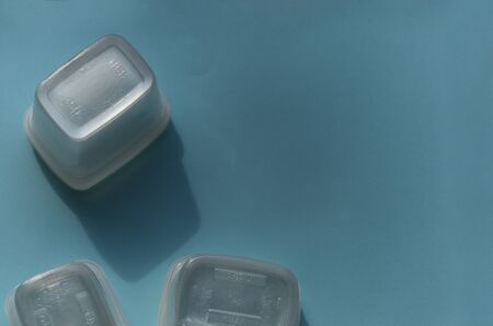 plastic containers on a blue background upturned with copy space