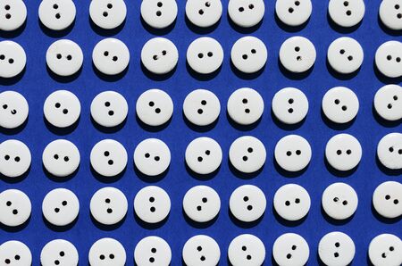 Pattern white wooden buttons on a blue background view from above