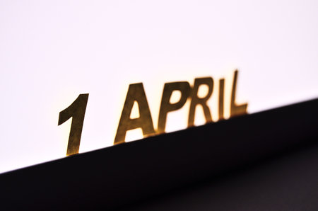 Inscription 1 April of yellow paper letters on the background of a glowing LED lampの写真素材