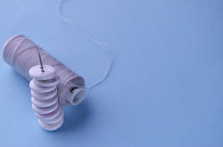 Banner nine wooden white stack buttons next to gray threads on a blue background with a copy space. High quality photoの写真素材