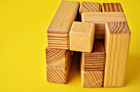 The wooden cube of the logical game close-up is not a yellow background with a copy space. Solving logical problems.の写真素材