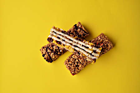 Banner three granola bars lie in the center of the frame on a yellow background view from above with...