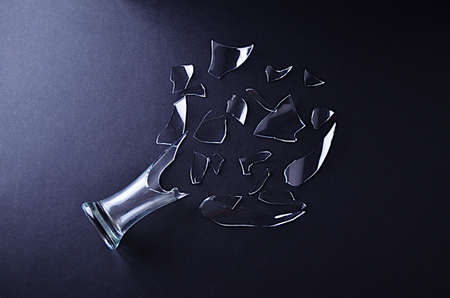Broken glass vase with decomposed shards of glass on a black backgroundの写真素材