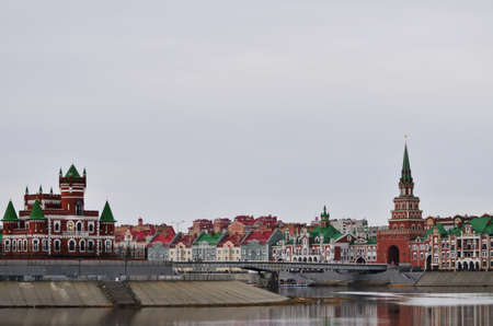 The new architecture of the city in the Brussels style of the Spasskaya Tower, the embankment of Bruges and the Theatre Bridge in cloudy weather. Russia Yoshkar Ola 01.05.2021のeditorial素材