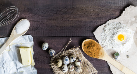 Coocking preparation set with flour, quail eggs, butter, sugar, cinnamon pouder, spoon and paper on...