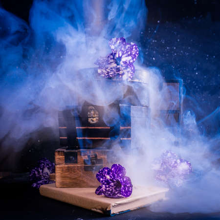 Magical concept. Smoke, boxes and violet flowers on dark backgroundの写真素材