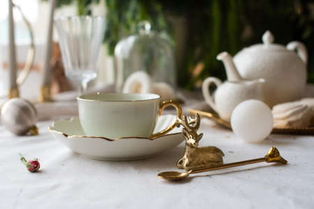 exquisite table setting for dinner. in the restaurant light porcelain with gold. modern decor deer.