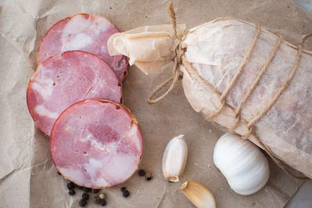 homemade village ham. pork, red meat. garlic and allspice. decorated in craft paper, tied with a...
