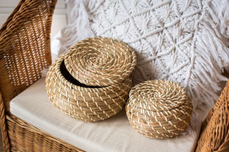 two wicker baskets made of vine, on a rattan chair. pillow macrame. eco, natural materials, eco-friendly. boho style.の写真素材