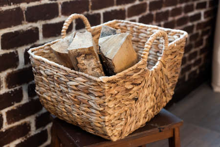 a wicker basket made of paper vine filled with firewood. recycling, eco, natural materials, eco-friendly. boho style, rustic, cozyの写真素材
