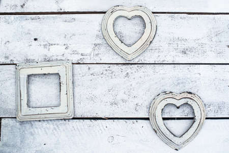 white old photo frames on a wooden background. in the shape of a heart. wall, interior