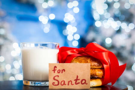 cookies, milk for santa. Christmas traditions. note for santa claus. the treat is tied with a red ribbon. bokeh, lightsの写真素材