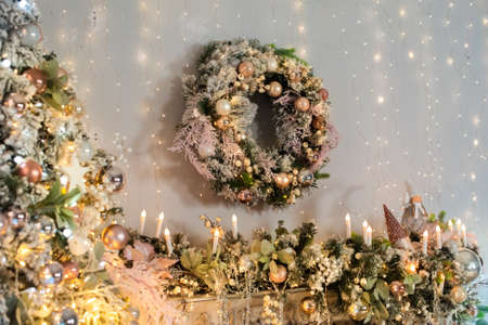 interior in pink and gold. Christmas tree, wreath are decorated with shiny balls, lights, candles. happy new yearの写真素材