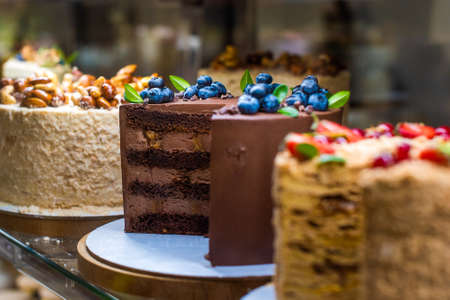 showcase with cakes. appetizing sweets with fruits and berries, figs, blueberries, raspberriesの写真素材