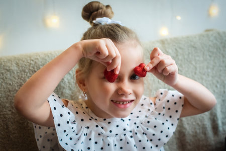 white girls hands hold a heart symbol. the baby plays, gives love. in the palms of red shiny toysの写真素材