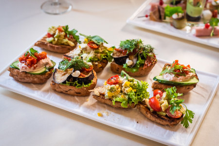 appetizers at the wedding reception. gourmet bruschetta with pate, zucchini, tomato, cucumber and herbs.の写真素材