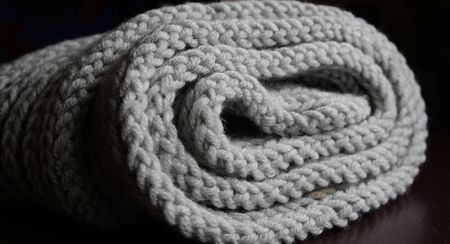 Abstract knitting fabric background. Gray texture background from merino knitted blanket, scandinavian minimalism backdrop with copy space, top view.の写真素材